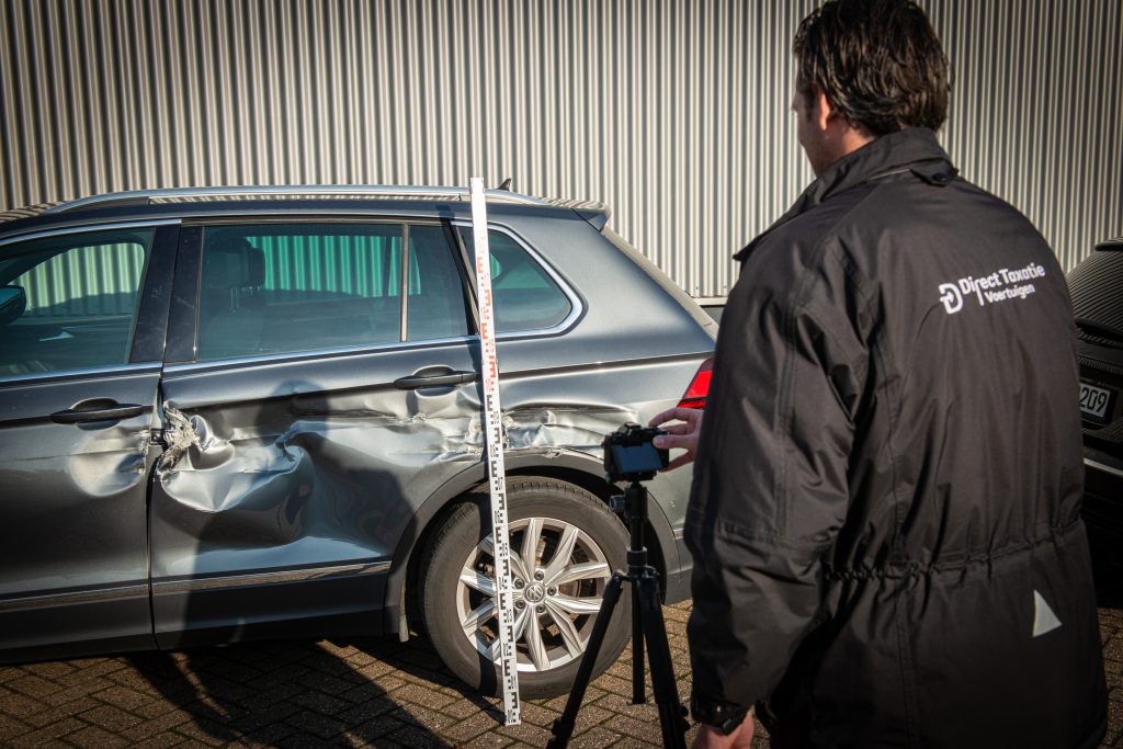 Schade-expert van Direct Taxatie Voertuigen die autoschade onderzoekt en technisch schadeonderzoek uitvoert op locatie